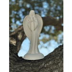 White angel figurine standing on a tree branch