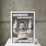 Greeting card with a baby holding bottles and the words "Congratulations!"