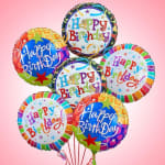 Cluster of colorful Happy Birthday balloons on a pink background