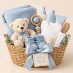 Baby gift basket with a teddy bear, blue clothing, and care items