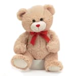Plush teddy bear with a red ribbon bow sitting on a white base