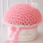 Large dome of pink roses in a round hatbox with a pink ribbon