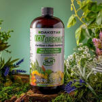 Bottle of plant fertilizer surrounded by flowers and greenery