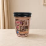 Pink floral-scented candle in a glass jar with a black lid