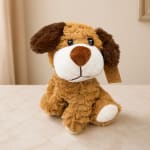 Plush dog toy with brown and white fur sitting on a tabletop