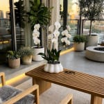 White orchids in a white ceramic pot on a wooden bench