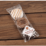 Two wrapped chocolate sandwich cookies on a wooden surface