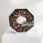 Birdseed wreath in a white hexagonal box with a purple bow