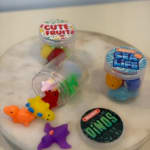 Three small clear jars of colorful animal-shaped candies on a round table