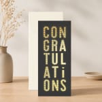 Congratulations card standing in front of an envelope on a tabletop