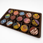 Tray of assorted decorated chocolates in a plastic box