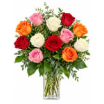 Mixed roses in a clear glass vase with greenery