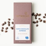 Box of dark chocolate espresso with coffee beans scattered around it