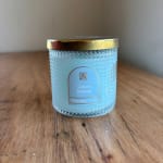 Blue scented candle in a textured glass jar with a gold lid