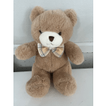 Brown teddy bear with a plaid bow tie