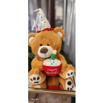 Plush teddy bear wearing a party hat and holding a birthday cupcake