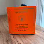 Orange Spongellé body wash buffer box on a wooden table