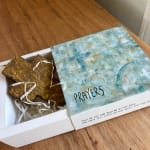 Gift box with a gold cross and a lid labeled "PRAYERS"