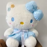 Hello Kitty plush toy in a blue dress with a ribbon bow