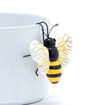 Bee-shaped decorative clip attached to a white mug