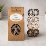 Box of chocolate-covered pretzels beside a stacked pretzel display