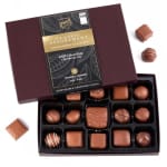 Box of assorted milk chocolates with several pieces outside the open lid
