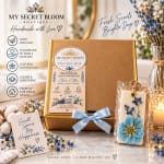 Gift box with a floral candle and space freshener, surrounded by blue and white flowers