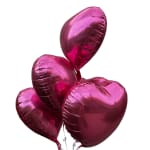 Cluster of metallic pink heart-shaped balloons on a white background