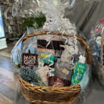 Gift basket with snacks, skincare items, and a small blue floral sprig