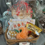 Gift basket with snacks, a jar, and a pumpkin-themed item wrapped in clear cellophane