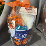 Halloween gift bucket with candy and a white plush item wrapped in clear plastic
