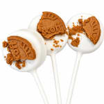 Three white cake pops topped with broken Biscoff cookies