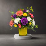 Colorful mixed flower arrangement in a yellow glass vase