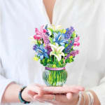 Person holding a shirt with a colorful flower vase graphic