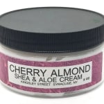 Jar of cherry almond shea and aloe cream with a black lid