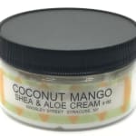 Jar of coconut mango shea and aloe cream with a black lid