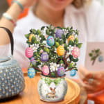 Decorative Easter tree in a rabbit vase with colorful hanging eggs