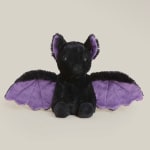 Black bat plush toy with purple wings on a plain background
