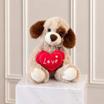 Plush dog holding a red heart with the word Love
