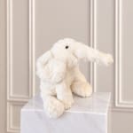 White plush elephant toy sitting on a marble pedestal