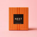 Boxed Nest New York Pumpkin Chai scented candle on a pink background