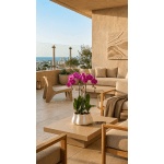 Potted pink orchid arrangement on a beige table in a modern patio seating area