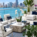 White orchids and potted tropical plants on a modern waterfront patio