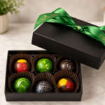 Box of assorted chocolates with a green ribbon