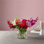 Mixed pink and red flower arrangement in a clear glass vase