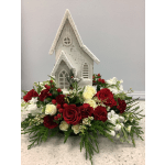 Red and white floral arrangement around a small white church decoration