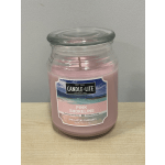 Pink scented candle in a glass jar with a lid