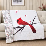 Quilted throw blanket with a red cardinal and berry branch pattern