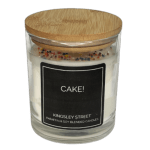 White candle in a glass jar with a wooden lid and black label