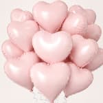 Cluster of pale pink heart-shaped balloons on a light background